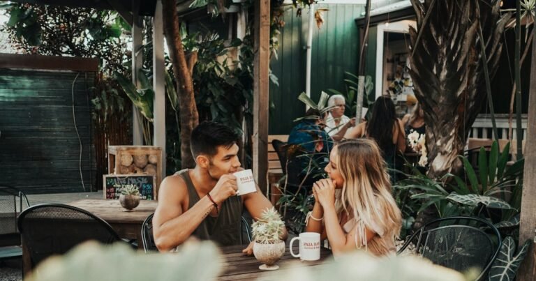 Two friends talking and listening over coffee at an outdoor café