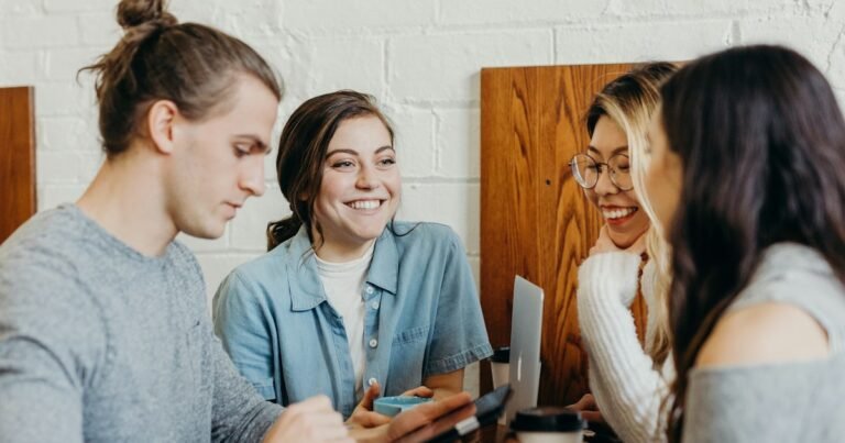 Group of young friends laughing together at a table