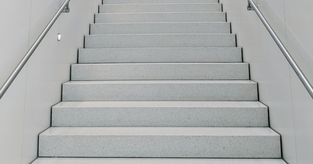 Bright white staircase leading upward, one step at a time