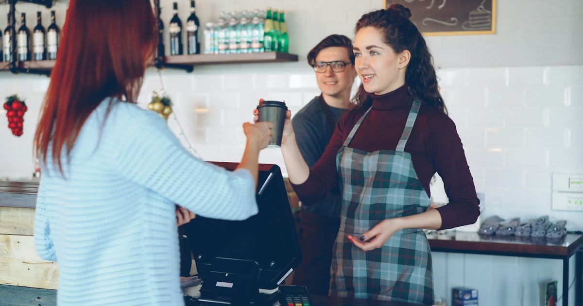 Friendly exchange between customers and a barista in a café