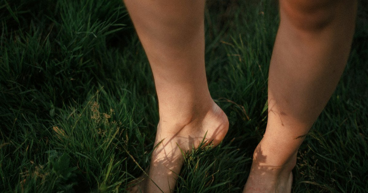 Bare feet standing on green grass