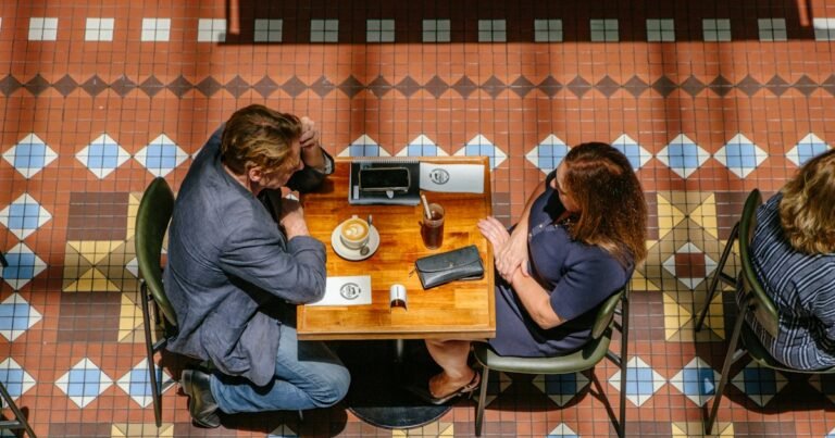 Two people sitting quietly at a café table seen from above