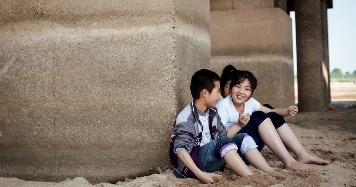 Two children sitting together and smiling shyly