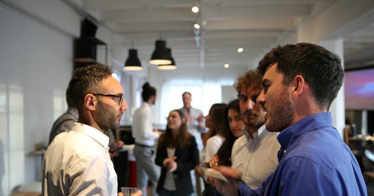 People standing and chatting in small groups at a networking event