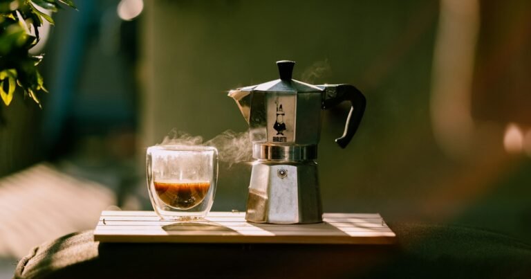 Cup of coffee and a moka pot in warm morning sunlight