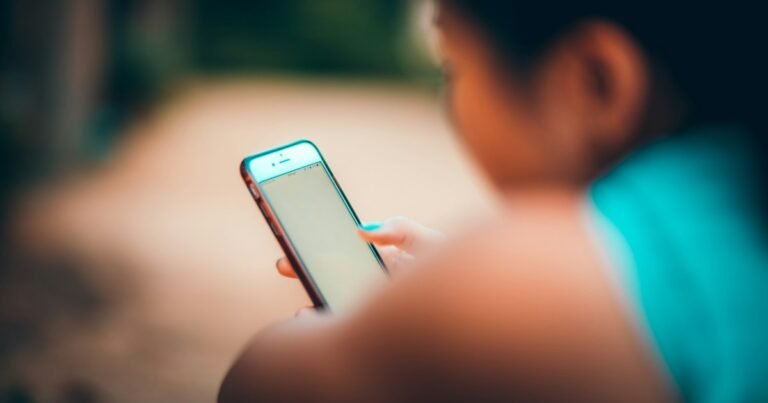 Person looking down at their phone, avoiding the world around them