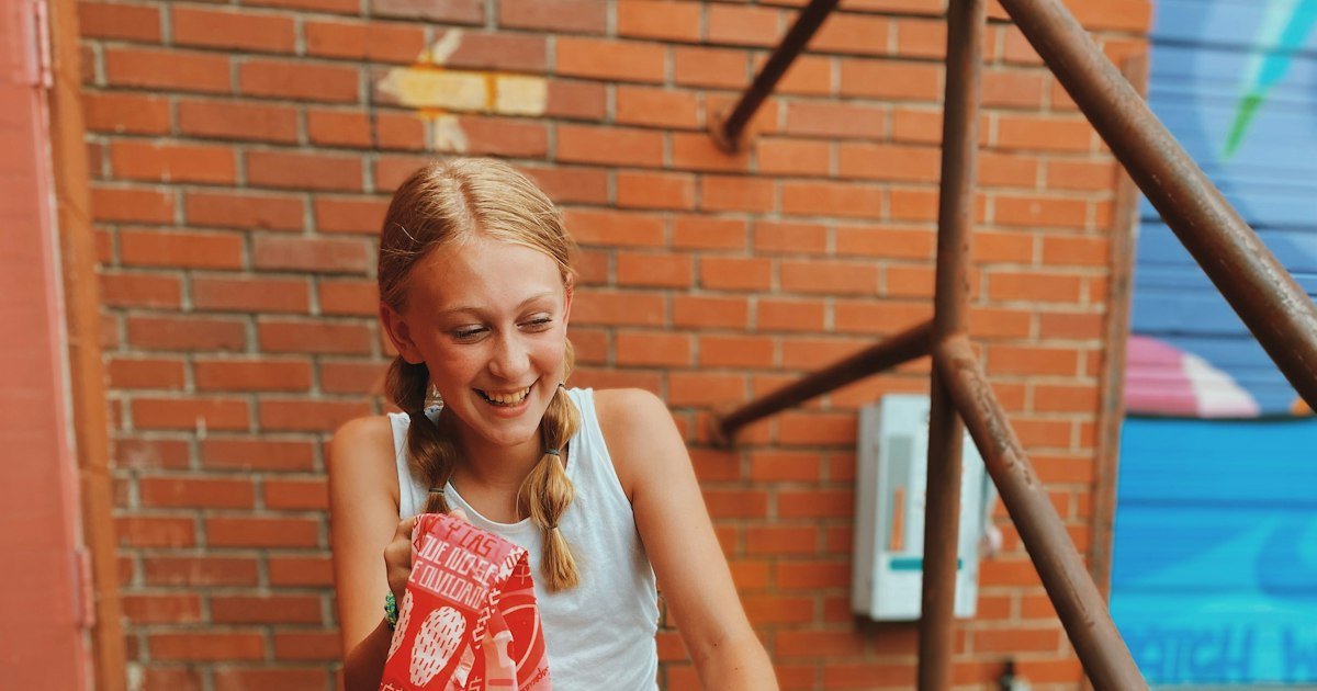 Smiling teenage girl holding a book, relaxed and confident