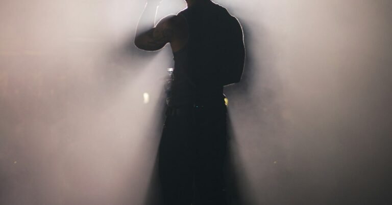 Silhouette of a person standing in a bright spotlight
