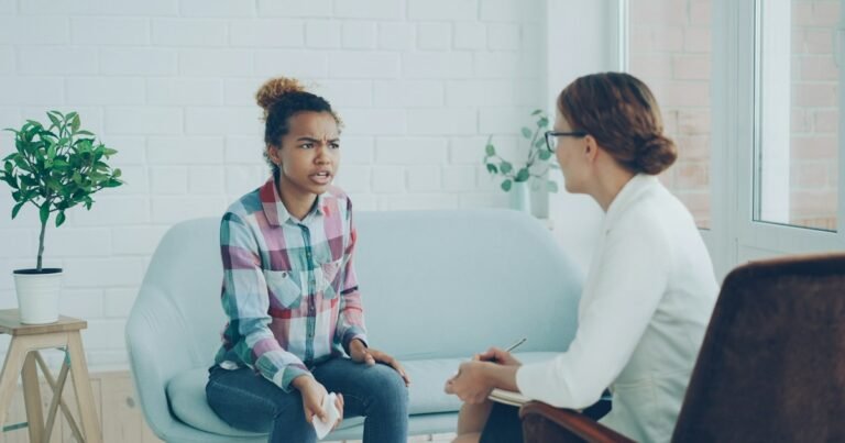 Young woman talking with a therapist in a bright office
