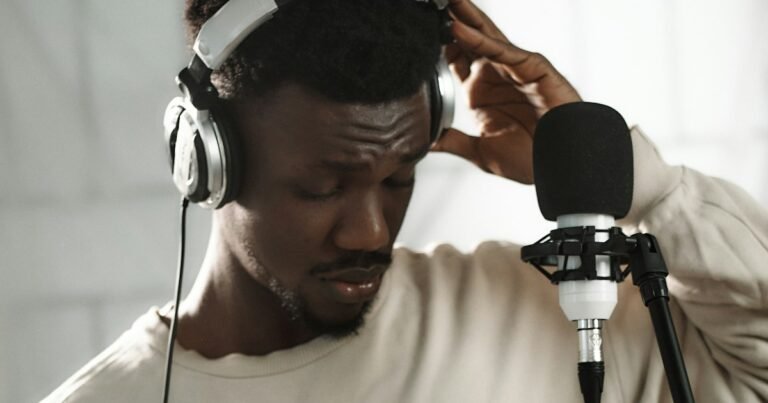 Man wearing headphones speaking into a studio microphone