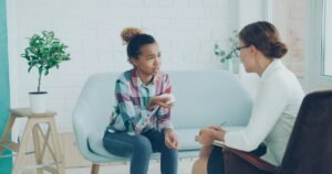 Young woman talking with a therapist in a bright room